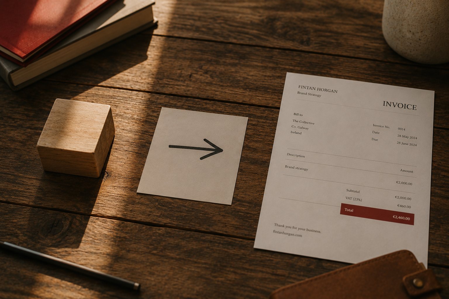 A wooden block, an arrow on paper, and a completed Irish invoice arranged in sequence on a wooden desk, illustrating workflow automation.